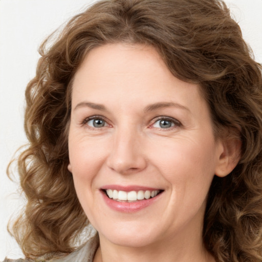 Joyful white young-adult female with medium  brown hair and green eyes