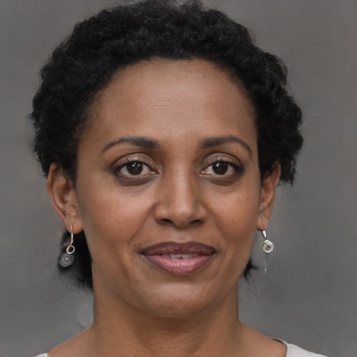 Joyful black adult female with short  brown hair and brown eyes