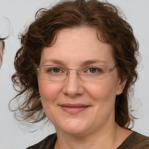 Joyful white adult female with medium  brown hair and blue eyes