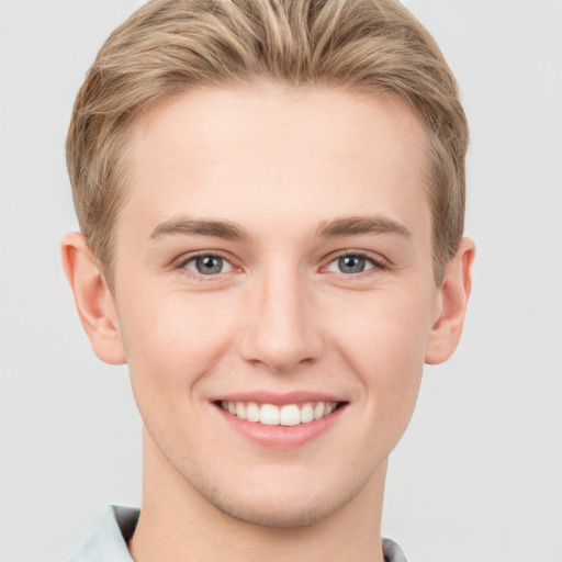 Joyful white young-adult male with short  brown hair and grey eyes