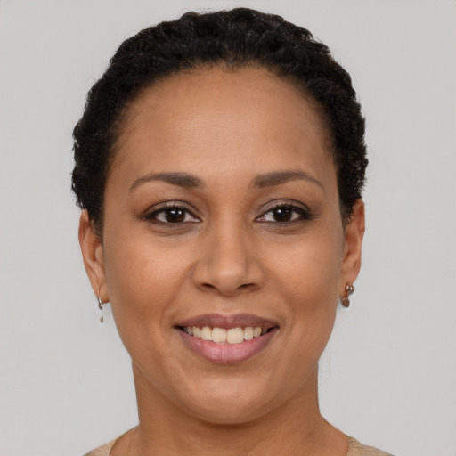 Joyful black adult female with short  brown hair and brown eyes