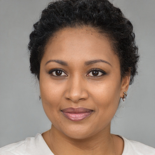 Joyful black young-adult female with short  brown hair and brown eyes
