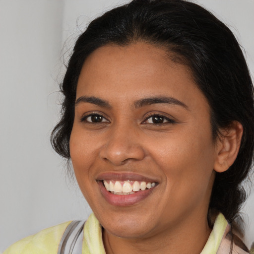 Joyful latino young-adult female with medium  brown hair and brown eyes