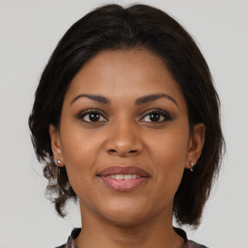 Joyful black young-adult female with medium  brown hair and brown eyes