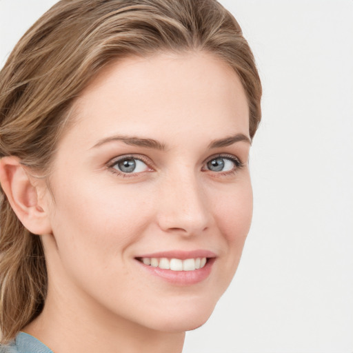 Joyful white young-adult female with long  brown hair and blue eyes