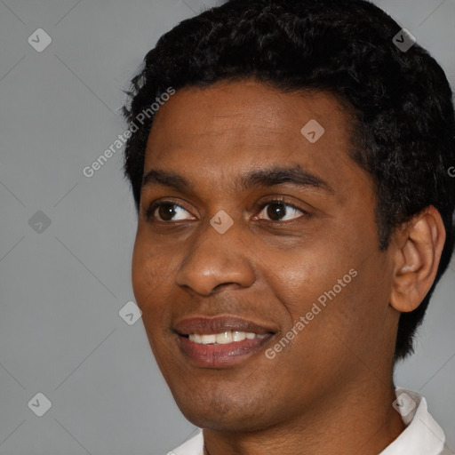 Joyful black young-adult male with short  black hair and brown eyes