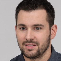 Joyful white young-adult male with short  black hair and brown eyes