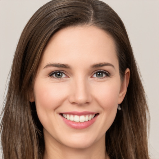 Joyful white young-adult female with long  brown hair and brown eyes