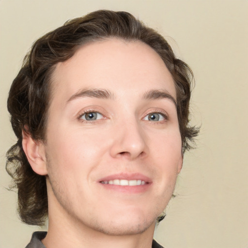 Joyful white young-adult male with medium  brown hair and grey eyes