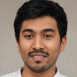 Joyful latino young-adult male with short  black hair and brown eyes