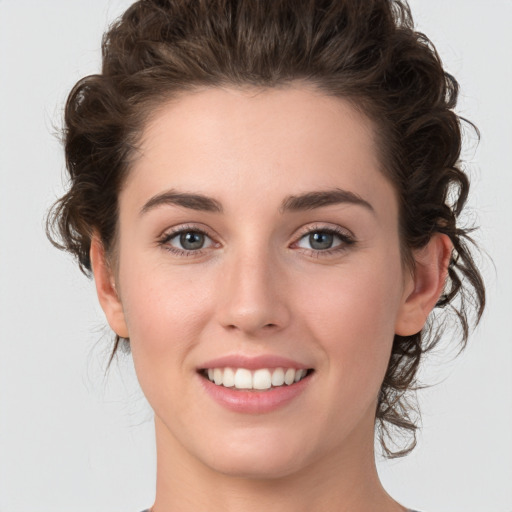 Joyful white young-adult female with medium  brown hair and green eyes