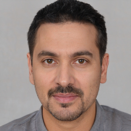 Joyful white young-adult male with short  black hair and brown eyes