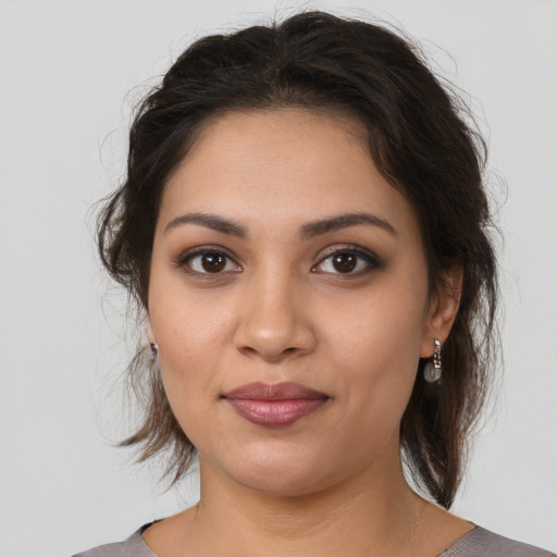 Joyful latino young-adult female with medium  brown hair and brown eyes
