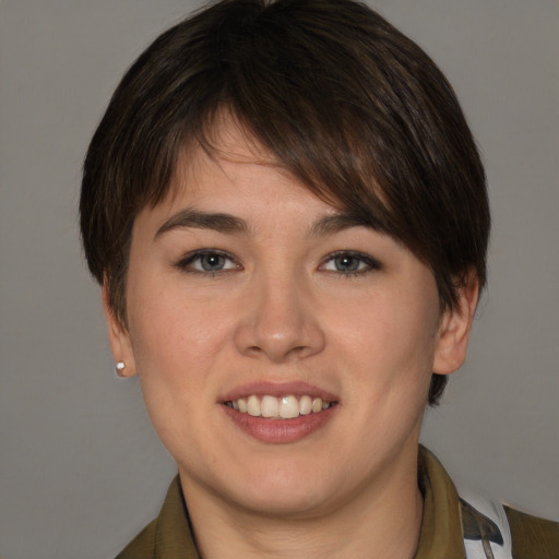Joyful white young-adult female with short  brown hair and grey eyes