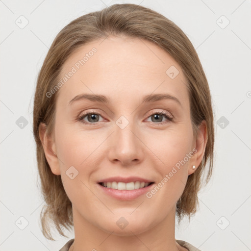 Joyful white young-adult female with medium  brown hair and grey eyes