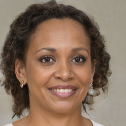 Joyful black adult female with medium  brown hair and brown eyes