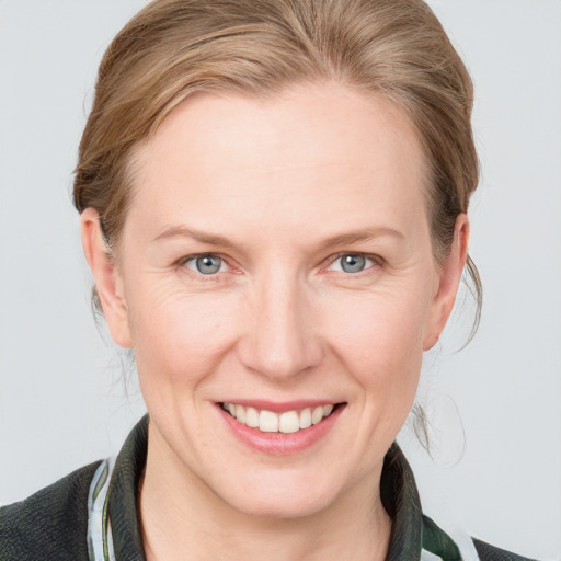 Joyful white adult female with medium  brown hair and blue eyes