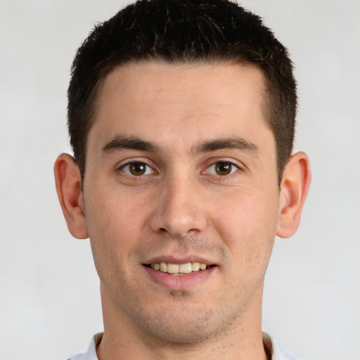 Joyful white young-adult male with short  brown hair and brown eyes