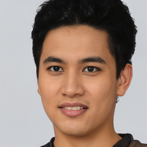 Joyful latino young-adult male with short  black hair and brown eyes