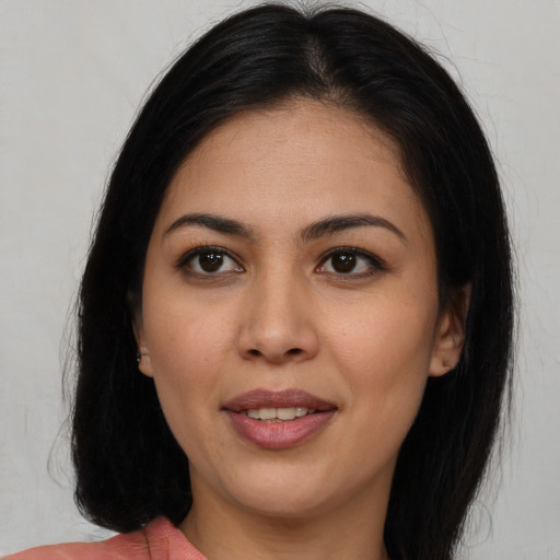 Joyful latino young-adult female with long  brown hair and brown eyes