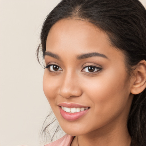 Joyful latino young-adult female with long  brown hair and brown eyes