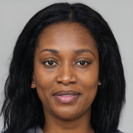 Joyful black young-adult female with long  black hair and brown eyes