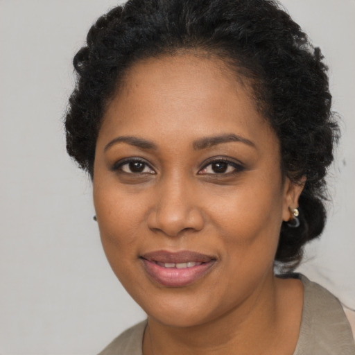 Joyful black adult female with long  brown hair and brown eyes