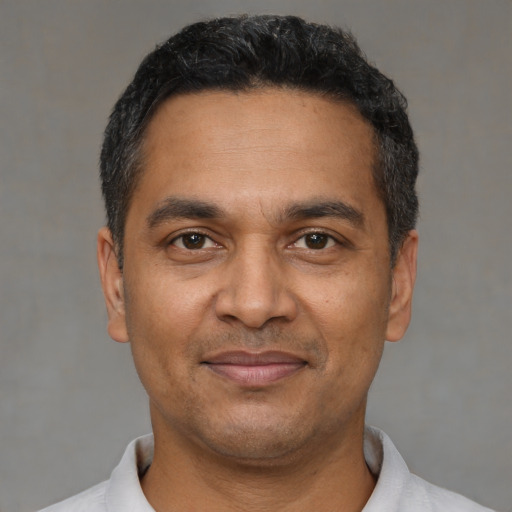 Joyful black adult male with short  black hair and brown eyes