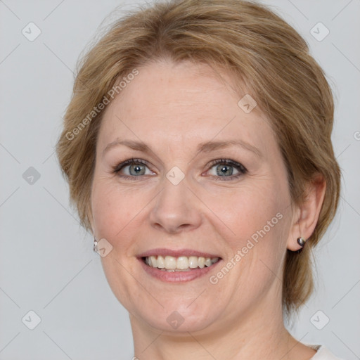 Joyful white adult female with medium  brown hair and blue eyes