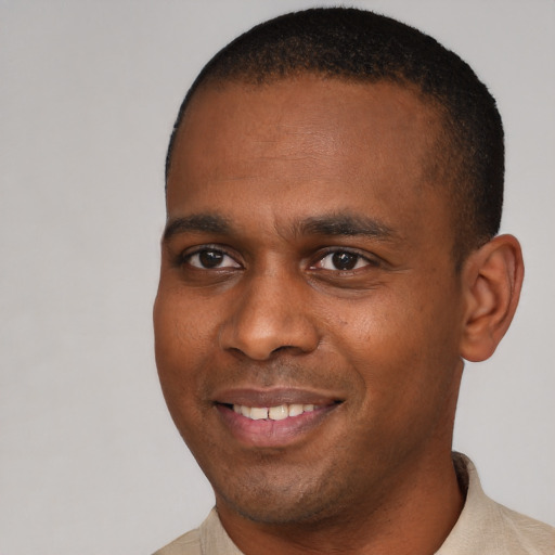 Joyful black young-adult male with short  brown hair and brown eyes
