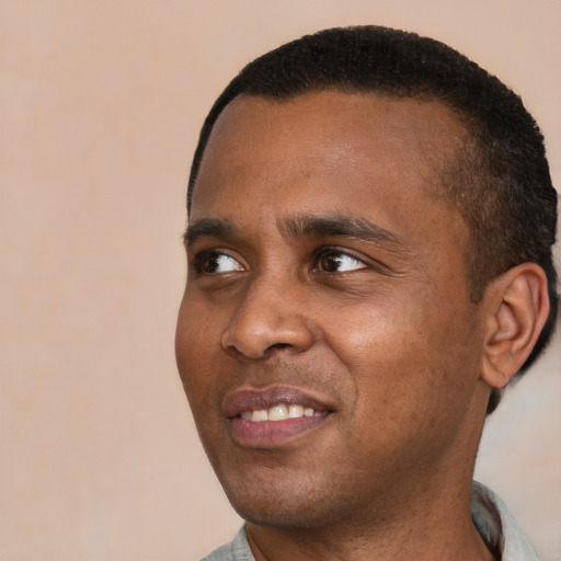 Joyful black young-adult male with short  black hair and brown eyes