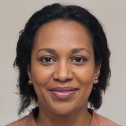 Joyful black adult female with medium  brown hair and brown eyes