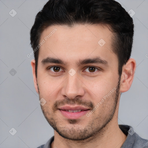 Joyful white young-adult male with short  black hair and brown eyes