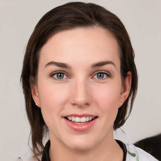 Joyful white young-adult female with medium  brown hair and grey eyes