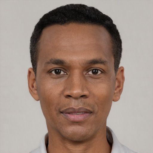 Joyful black adult male with short  black hair and brown eyes