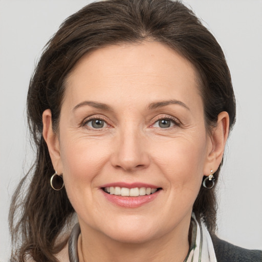 Joyful white adult female with medium  brown hair and brown eyes