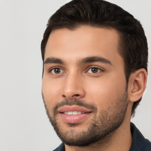 Joyful white young-adult male with short  black hair and brown eyes