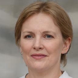 Joyful white adult female with medium  brown hair and blue eyes