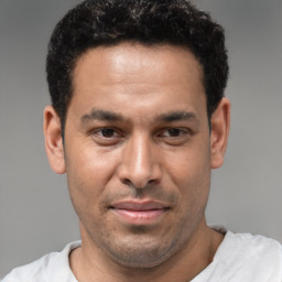 Joyful latino young-adult male with short  brown hair and brown eyes