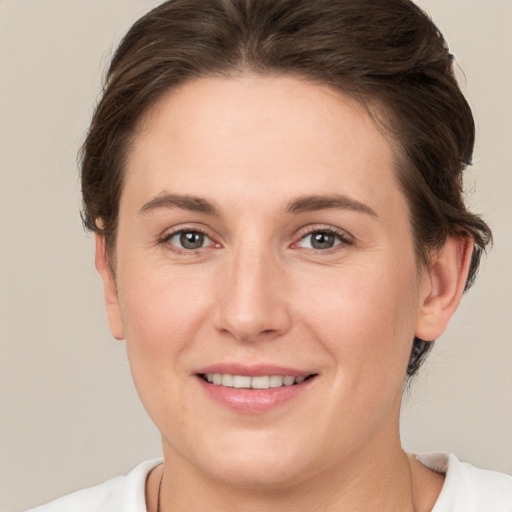 Joyful white young-adult female with short  brown hair and grey eyes