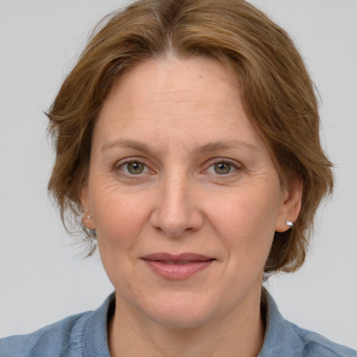 Joyful white adult female with medium  brown hair and blue eyes