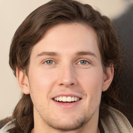 Joyful white young-adult male with medium  brown hair and grey eyes