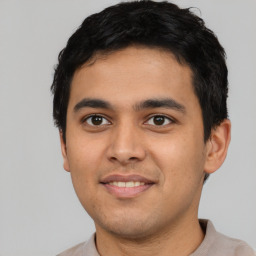 Joyful latino young-adult male with short  black hair and brown eyes