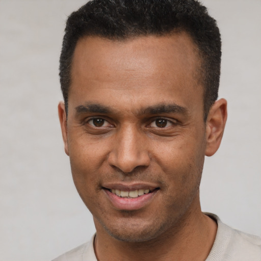 Joyful latino young-adult male with short  black hair and brown eyes