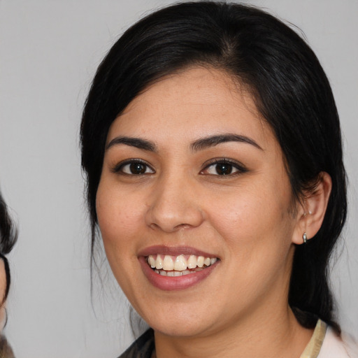 Joyful latino young-adult female with medium  black hair and brown eyes