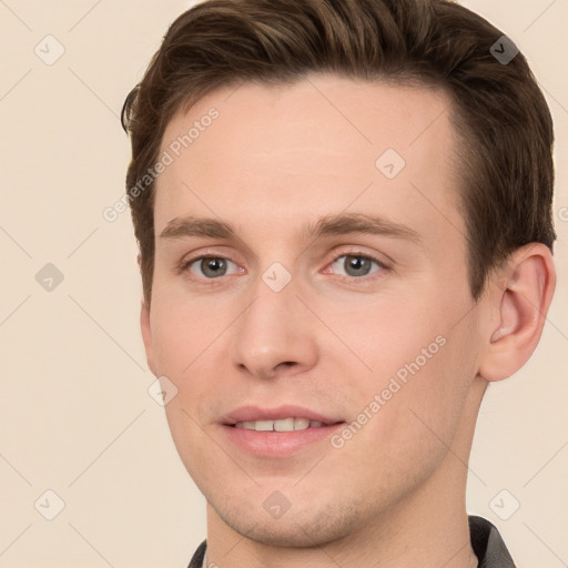 Joyful white young-adult male with short  brown hair and grey eyes