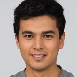 Joyful latino young-adult male with short  brown hair and brown eyes