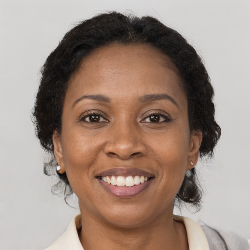 Joyful black adult female with medium  brown hair and brown eyes