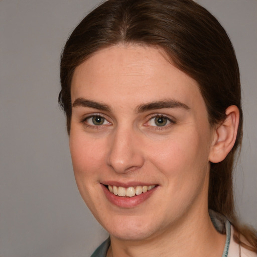 Joyful white young-adult female with medium  brown hair and grey eyes