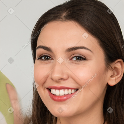 Joyful white young-adult female with long  brown hair and brown eyes